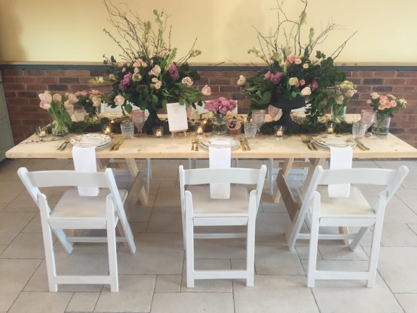 white folding chairs with plank table